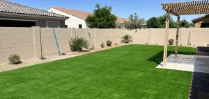 Finished artificial turf backyard with pergola and block wall at a Chandler AZ home