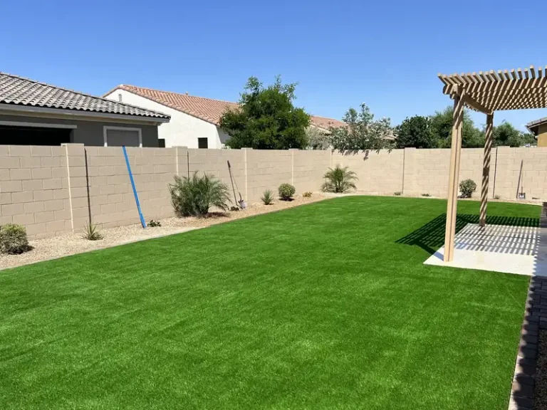Finished artificial turf backyard with pergola and block wall at a Chandler AZ home