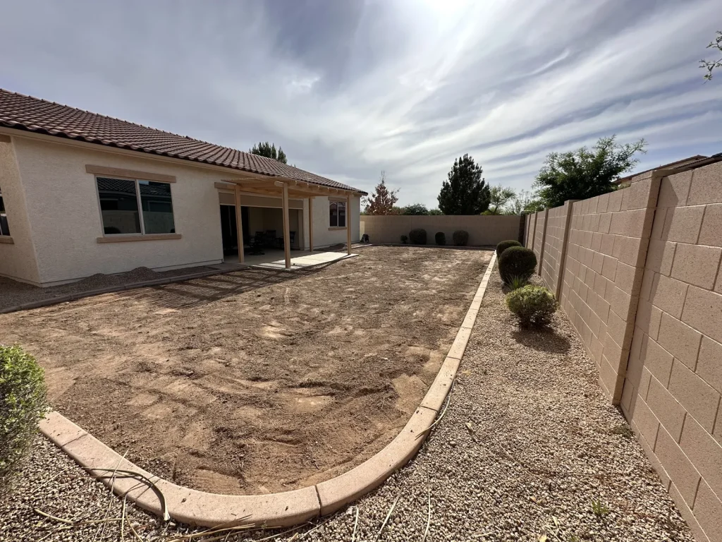 Backyard graded and edged with concrete curbing, ready for new landscaping