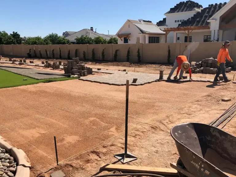CGL Landscaping crew building a block wall and paver border during a full backyard hardscape build