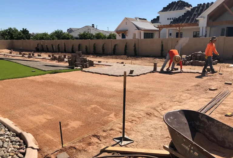 CGL Landscaping crew building a block wall and paver border during a full backyard hardscape build
