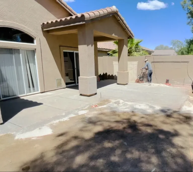 Fresh concrete patio slab under a covered back porch