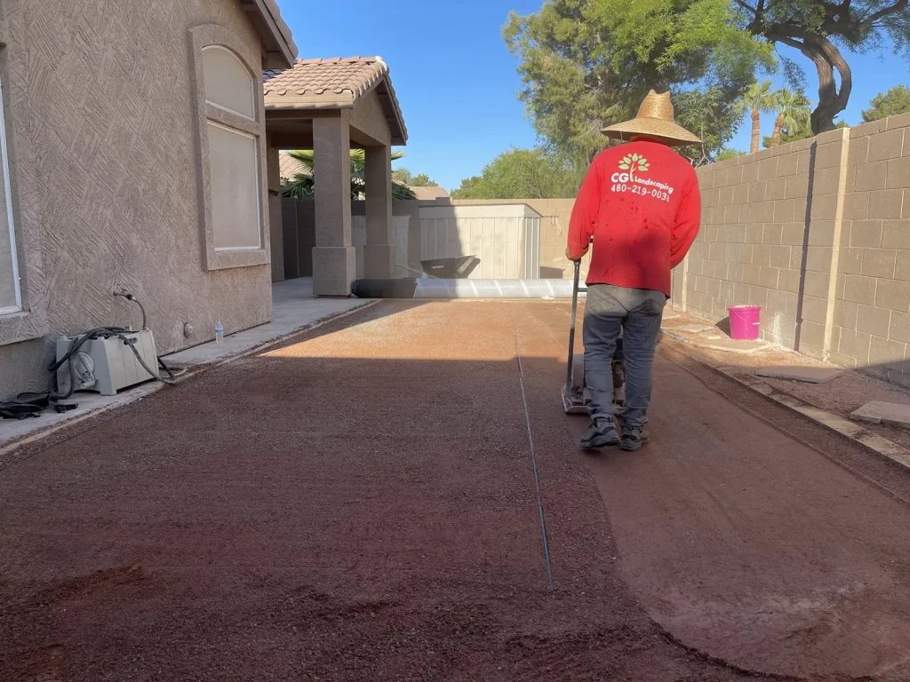 CGL crew member raking decomposed granite in a side yard