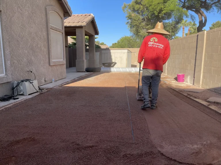 CGL crew member raking decomposed granite in a side yard