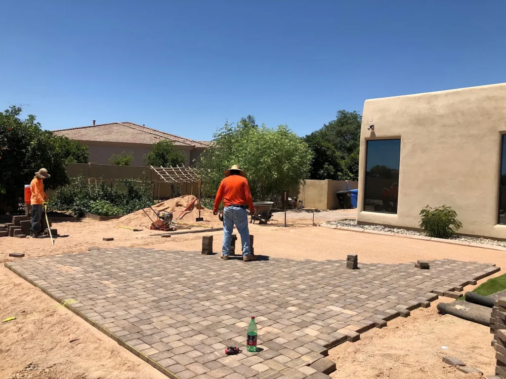 Paver patio install in progress with the crew working behind it