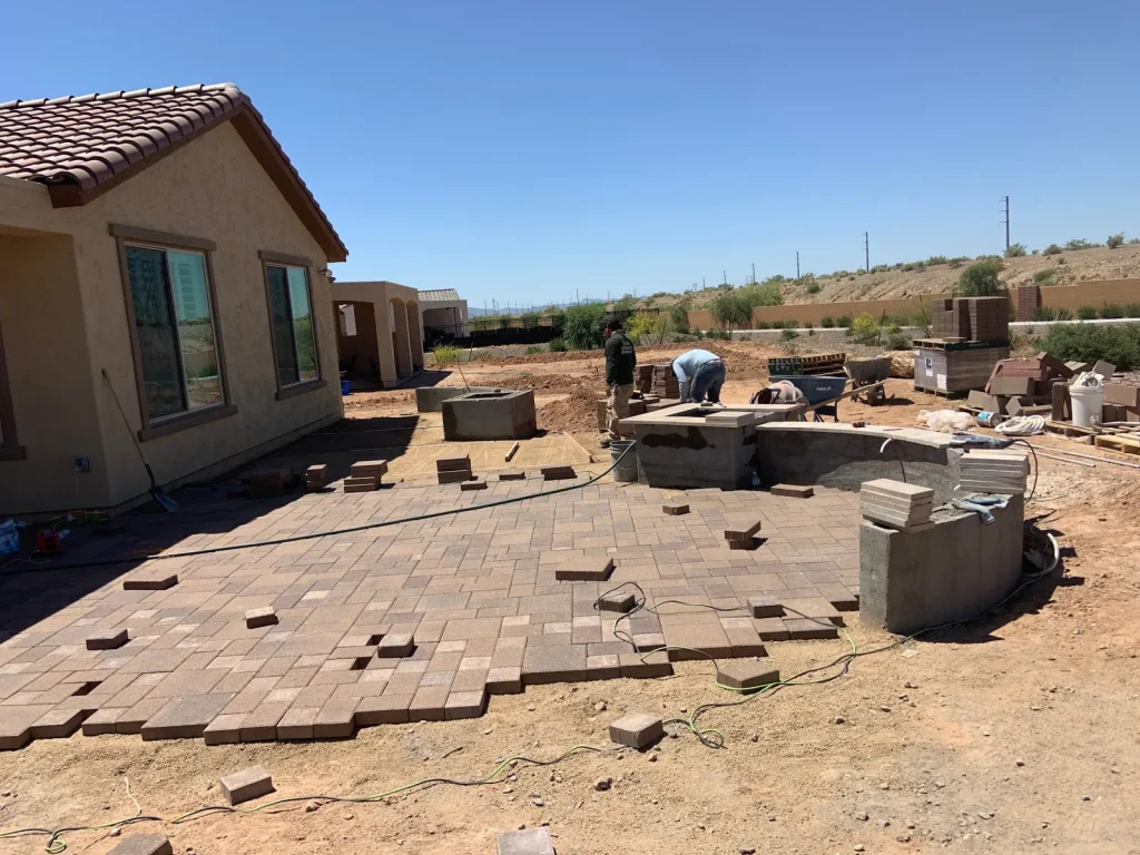 Paver patio with block seating and an outdoor kitchen island under construction